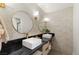 Modern bathroom featuring dual sinks, black countertops, gold fixtures, round mirrors and decorative wall tiles at 6975 Darby Ave, Las Vegas, NV 89117
