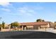 Exterior view of a single-story home with a tile roof, gated entry, and well-maintained landscaping at 6975 Darby Ave, Las Vegas, NV 89117