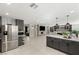 Open concept kitchen featuring grey cabinets, a center island, and seamless flow into the living area at 6975 Darby Ave, Las Vegas, NV 89117