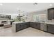 Spacious kitchen with grey cabinets, an island with seating, and seamless flow into the living space at 6975 Darby Ave, Las Vegas, NV 89117