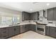 Well-appointed kitchen featuring stainless appliances, grey cabinetry, and quartz countertops at 6975 Darby Ave, Las Vegas, NV 89117