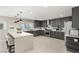 Stylish kitchen with gray cabinets, white countertops, and a large island with seating and modern pendant lighting at 6975 Darby Ave, Las Vegas, NV 89117