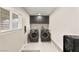 Functional laundry room with modern washer and dryer, gray cabinets and white walls at 6975 Darby Ave, Las Vegas, NV 89117