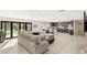 Open concept living area features a modern kitchen, a large sectional, and access to the backyard at 6975 Darby Ave, Las Vegas, NV 89117