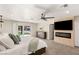 Bright main bedroom with a ceiling fan, a TV and fireplace, and sliding glass doors leading to a pool view at 6975 Darby Ave, Las Vegas, NV 89117