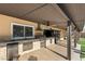 Covered outdoor kitchen with stainless steel appliances, granite countertops, and ample space for cooking and dining at 6975 Darby Ave, Las Vegas, NV 89117