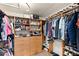 Spacious walk-in closet with custom wood shelving and drawers for organized storage of clothing and accessories at 6975 Darby Ave, Las Vegas, NV 89117