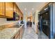 Well-appointed kitchen with granite countertops, black appliances, wooden cabinets, and an open view into dining area at 730 S Royal Crest Cir # 426, Las Vegas, NV 89169