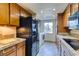 Kitchen with granite countertops, black appliances, and wood cabinets and a view of the nearby washer and dryer at 730 S Royal Crest Cir # 426, Las Vegas, NV 89169