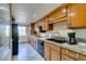 Galley kitchen features granite countertops, black appliances, wood cabinets, and plenty of natural light from the window at 730 S Royal Crest Cir # 426, Las Vegas, NV 89169