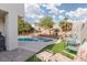 Backyard featuring a pool, spa, palm trees, and a grassy area for relaxing at 7317 Bosky Springs St, Las Vegas, NV 89131