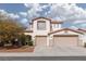 Charming two-story home featuring a red tile roof, dual garages, and desert landscaping under a cloudy sky at 7317 Bosky Springs St, Las Vegas, NV 89131