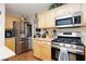 Bright kitchen featuring stainless steel appliances, wood cabinets, and granite countertops at 7317 Bosky Springs St, Las Vegas, NV 89131