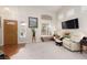 Cozy living room with vaulted ceiling, large windows, comfortable seating, and a TV at 7317 Bosky Springs St, Las Vegas, NV 89131