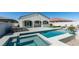 A beautiful backyard featuring a pool, spa, covered patio with bar seating, and lush landscaping at 792 Drammatico Pl, Henderson, NV 89011