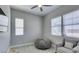 Cozy bedroom with comfortable seating, natural light from large windows, and a mounted TV at 792 Drammatico Pl, Henderson, NV 89011