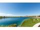 Picturesque view of community pond with blue water, landscaped shoreline, and mountain views in the distance at 792 Drammatico Pl, Henderson, NV 89011