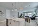Open kitchen with a center island, modern lighting, and seamless flow into the living area with pool view at 792 Drammatico Pl, Henderson, NV 89011