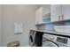 Bright laundry room with modern appliances, built-in cabinets, counter space, and neutral color palette at 792 Drammatico Pl, Henderson, NV 89011