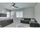 Spacious primary bedroom featuring a cozy seating area, large window, ceiling fan, and neutral color scheme at 792 Drammatico Pl, Henderson, NV 89011
