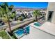 Aerial view showcasing a home with outdoor living, a pool, mature palm trees, and city views in the distance at 795 Glistening Light Ct, Henderson, NV 89052