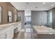 Elegant primary bathroom with dual vanity, soaking tub, walk-in shower, and sleek finishes at 795 Glistening Light Ct, Henderson, NV 89052