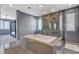 Open main bathroom with soaking tub, walk-in shower, and four-poster bed in background at 795 Glistening Light Ct, Henderson, NV 89052