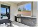 Outdoor kitchen with stainless steel grill, stone accents, and patio seating area at 795 Glistening Light Ct, Henderson, NV 89052