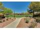 View of a lush, well-maintained common area featuring a large lawn, trees, walking path and greenery at 8129 Jim Steele Falls St, North Las Vegas, NV 89085