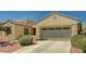 Inviting single-story home with a two-car garage and desert landscaping under a clear blue sky at 8129 Jim Steele Falls St, North Las Vegas, NV 89085