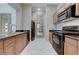 Kitchenette with stainless steel appliances, tile floor, wooden cabinets, and granite countertops at 8129 Jim Steele Falls St, North Las Vegas, NV 89085