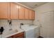 Bright laundry room with washer, dryer, sink, and upper cabinets for storage at 8129 Jim Steele Falls St, North Las Vegas, NV 89085