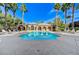 Community pool with lounge chairs and clear blue water surrounded by desert landscaping and palm trees at 8129 Jim Steele Falls St, North Las Vegas, NV 89085