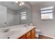 Bathroom featuring a double vanity, large mirror, and wood-look flooring at 1036 Kennebunk Cir, Henderson, NV 89015