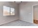 Neutral bedroom featuring gray carpet and a window with views of the backyard at 1036 Kennebunk Cir, Henderson, NV 89015