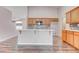 Open kitchen featuring wood cabinets, modern countertops, stylish backsplash, and wood-look flooring at 1036 Kennebunk Cir, Henderson, NV 89015