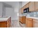 Well-lit kitchen features wood cabinets, modern countertops, stylish backsplash, and plank flooring at 1036 Kennebunk Cir, Henderson, NV 89015