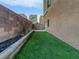Backyard area featuring artificial turf and a stone border with a brick wall for privacy at 10537 Headwind Ave, Las Vegas, NV 89129