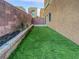 Backyard area featuring artificial turf and a stone border with a brick wall for privacy at 10537 Headwind Ave, Las Vegas, NV 89129
