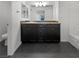 Modern bathroom with dark vanity, sleek sink, drawers, and a framed mirror above the vanity at 10537 Headwind Ave, Las Vegas, NV 89129