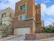 Exterior view of a two-story home with a neutral color scheme, attached garage, and landscaped front yard at 10537 Headwind Ave, Las Vegas, NV 89129