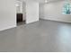 Bright, open-concept room featuring concrete floors and an adjoining area with dark wood cabinets at 10537 Headwind Ave, Las Vegas, NV 89129