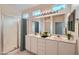 Bathroom features double vanity sinks, tile flooring, updated lighting, and a shower at 10580 Riva Grande Ct, Las Vegas, NV 89135