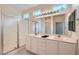 Bright bathroom features a double sink vanity, large mirror and glass-enclosed shower at 10580 Riva Grande Ct, Las Vegas, NV 89135