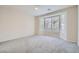 Spacious bedroom with neutral carpet, ceiling fan, and large windows at 10580 Riva Grande Ct, Las Vegas, NV 89135