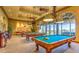 Well-lit billiards room featuring multiple pool tables, stylish lighting, and comfortable seating for residents at 10580 Riva Grande Ct, Las Vegas, NV 89135