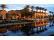Elegant clubhouse reflected in calm waters, framed by palm trees, showcasing upscale community amenities at 10580 Riva Grande Ct, Las Vegas, NV 89135