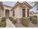 Beautiful front entrance with manicured shrubs, rock landscaping, and elegant architectural features at 10580 Riva Grande Ct, Las Vegas, NV 89135