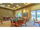 Spacious game room with card tables, chairs, and serene views, perfect for friendly gatherings and entertainment at 10580 Riva Grande Ct, Las Vegas, NV 89135