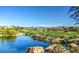 Scenic view of a golf course with a lake, lush green fairways, and mountain views in the distance at 10580 Riva Grande Ct, Las Vegas, NV 89135